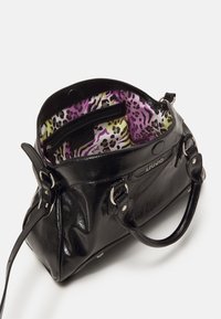 Sac à main en cuir noir avec deux poignées, ouverture sur le dessus montrant une doublure intérieure imprimée léopard violet, jaune et noir et une poche intérieure zippée.