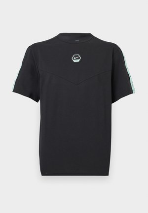 Μαύρο μπλουζάκι Nike με κοντά μανίκια, μπαλώμα σε μίντ πράσινο χρώμα με το λογότυπο στο στήθος και αντίστοιχες μίντ πράσινες λωρίδες με λογότυπο κατά μήκος των μανικιών.