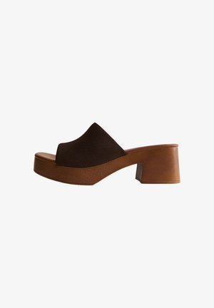 Mule marrón de punta abierta con un tacón medio grueso de madera y una amplia tira superior de ante marrón oscuro.