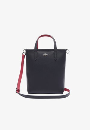 Borsa tote in pelle nera con trama a graniglia, dotata di manici corti, una lunga tracolla rossa regolabile e un dettaglio logo argentato.