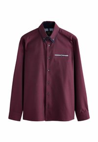 Camisa de manga larga burdeos con un tejido texturizado, cuello y puños en azul oscuro en contrate, y detalle de bolsillo en el pecho con un patrón.