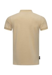 Beige polo shirt with a textured fabric, short sleeves, and a classic collar. Features a small logo tag on the bottom side seam.