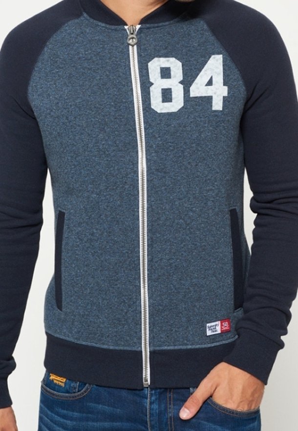 Zip-up huvtröja i mörkblått och grått, med raglanärmar, siffran "84" i vitt, två sidofickor samt ribbade mudd och nederkant.