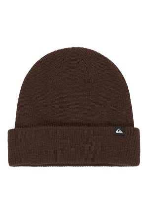 Brown knit beanie with a folded cuff, featuring a small black and white logo tag on the side. Textured fabric with a close-knit pattern.