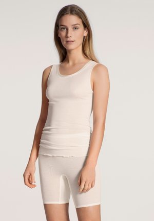 Lichtbeige naadloze tanktop met bandjes en bijpassende shorts tot halverwege de dij, gemaakt van glad, rekbaar materiaal en met een aansluitend ontwerp.