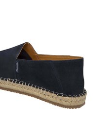 Scarpa slip-on in suede blu navy con suola in corda di giuta, caratterizzata da una forma arrotondata e una finitura texture. All'interno, presenta una fodera liscia di colore tan a contrasto.