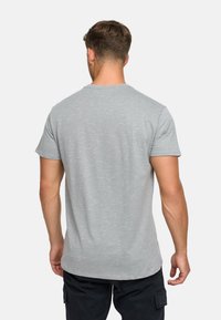 Hellgraues T-Shirt mit kurzen Ärmeln und rundem Ausschnitt aus einem weichen, strukturierten Stoff. Minimalistisches Design ohne sichtbare Muster oder Akzente.