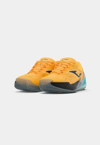 Gelbe Sportschuhe mit einer strukturierten Oberseite, versehen mit einem schwarzen Logo und einem durchsichtigen blauen Akzent an der Sohle. Entworfen für Agilität und Grip.