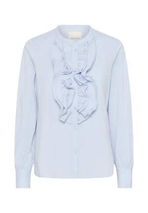 Lichtblauwe blouse met lange mouwen, met knoopsluiting aan de voorkant en verticale rimpeldetails langs de knoopsluiting.