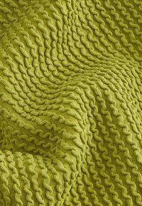 Couverture tricotée en vert vif, présentant un motif ondulé texturé. Le matériau semble doux et épais, mettant en valeur la chaleur et le confort.