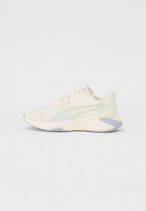 Chaussure de running beige clair avec des accents vert néon et gris, fermeture à lacets et semelle épaisse et rembourrée sur fond blanc uni.