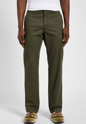 Pantaloni cargo olive con vestibilità dritta, dotati di tasche laterali e un tessuto robusto. Abbinati a sneakers marroni per un contrasto.