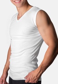 White sleeveless V-neck tank top made from soft, smooth cotton, fitted design, highlighting the silhouette, with a seamless hem.