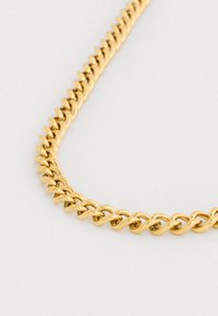 Kullast kaelakee, mis koosneb omavahel seotud keerutatud lülidest, sileda tekstuuri ja läikiva pinnaga neutraalse tausta ees.