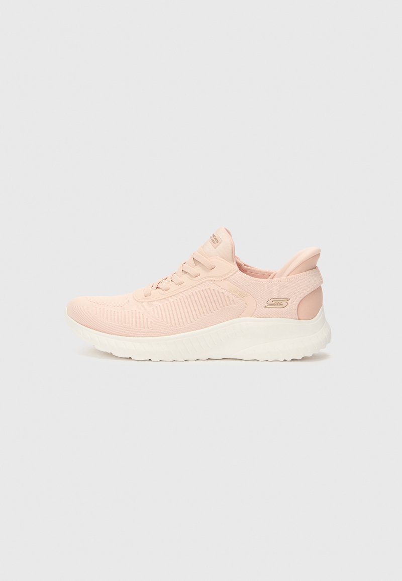 Light pink athletic shoes with a textured mesh upper, a cushioned white sole, and a subtle logo on the heel. Features laces and a seamless design.