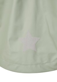 Hellgrüner, glatter Stoff mit einem silbernen Glitzerstern-Akzent. Abgerundeter Saum mit Nähedetails. Einfaches, minimalistisches Design.