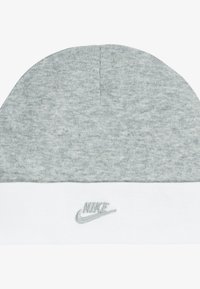 Căciulă gri tricotată, cu manșetă albă. Prezintă un mic logo Nike brodat în gri pe manșetă. Textură moale, vârf rotunjit.