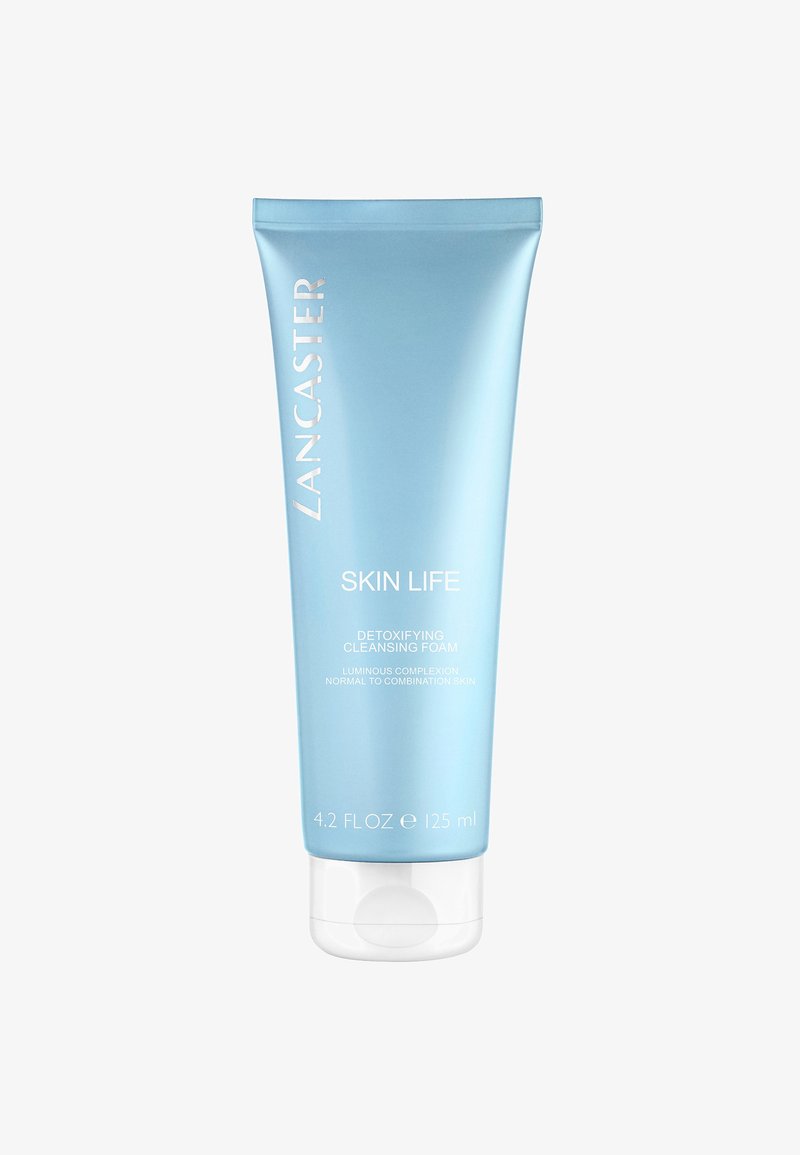 Tubo di plastica azzurro chiaro con un coperchio a vite bianco. Il testo sulla parte anteriore include "Lancaster," "Skin Life," e dettagli del prodotto in bianco.