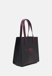 Zwarte tote bag met een gestructureerde afwerking, voorzien van donkerroze graphics en contrasterende diep paarse handvatten. Vierkante vorm met een open ontwerp aan de bovenkant.