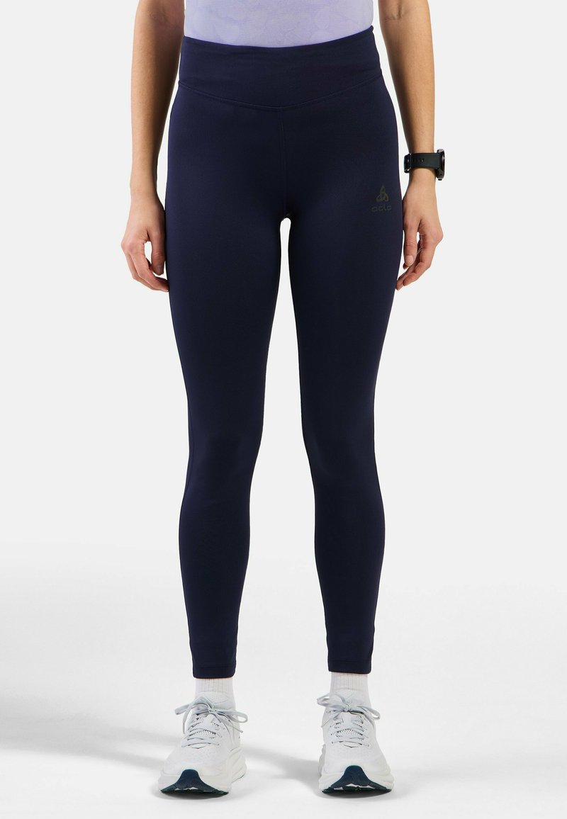 Marineblaue High-Waist-Leggings aus dehnbarem Stoff, mit einer glatten Textur und einem kleinen Logo-Emblem am linken Oberschenkel.