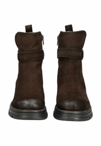 Botas de tobillo de ante marrón con un acabado suave, que cuentan con un cierre de cremallera, punta redonda y una suela de goma negra resistente. Detalle de correa ajustable en el tobillo.