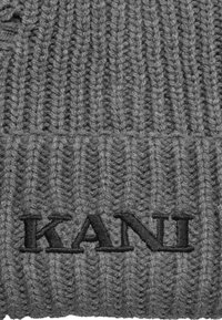 Berretto di lana grigia con un motivo a coste, con un logo ricamato nero "KANI" sulla parte anteriore. Materiale in filato morbido e texturizzato.