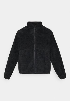 Svart fleecejakke med full glidelås, høy krage og lange ermer, laget av teksturert sherpa-materiale.