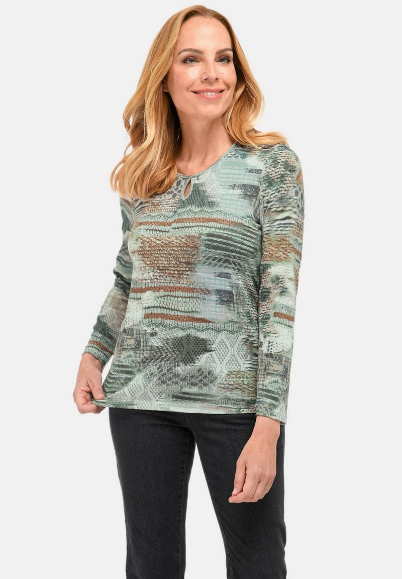 Langärmlige top in een gestructureerde stof, met een groen en bruin abstract patroon, ronde halslijn met een klein sleufdetail.