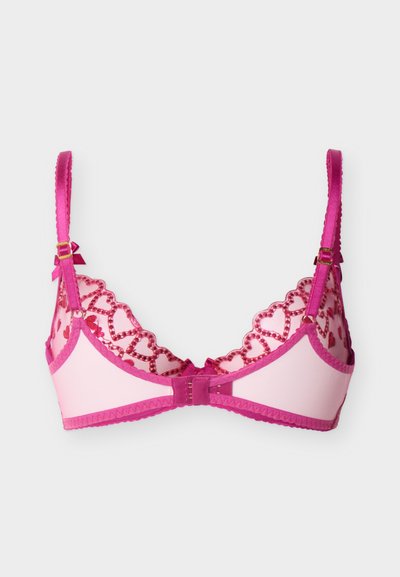 Ροζ σουτιέν με ρυθμιζόμενους ιμάντες, λεπτομέρειες δαντέλας σε σχήμα καρδιάς και κλείσιμο με αγκράφα στην πλάτη σε λευκό φόντο.