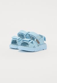 Blaue Sandalen mit strukturierten Stoffriemen, verstellbaren Klettverschlüssen und einer gepolsterten Sohle. Leichtes Design, geeignet für lässige Anlässe.