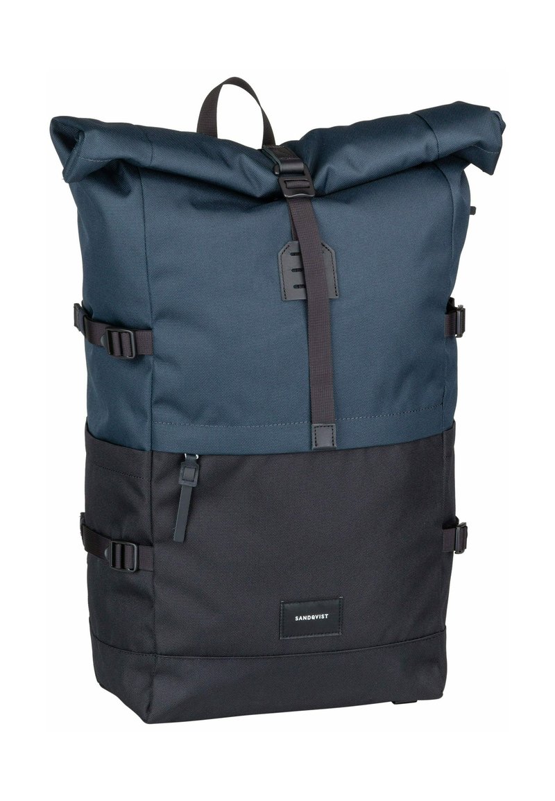 Mochila con tapa enrollable en azul oscuro y negro, hecha de tela texturizada, con correas ajustables, hebilla metálica y un parche de logo en el frente.