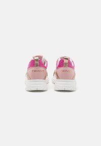 Zapatillas que combinan materiales en tonos rosa, blanco y dorado metálico, con una suela blanca acolchada y detalles de marca en el talón.