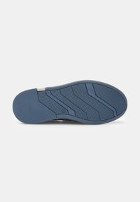 Talpa de pantof din cauciuc, cu un model texturat albastru, cu striții în zigzag și gripuri circulare pentru tracțiune. Accentuată cu un detaliu argintiu.