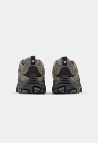 Grijze wandelschoenen van mesh en suède materiaal, met een robuust ontwerp, gestructureerde hak en contrasterende zwarte en gele accenten.