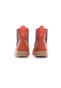 Botas de tobillo de lona naranja con paneles laterales negros, pestañas de tirón y una suela de goma color beige. Presentan una textura suave y un diseño de punta redondeada.