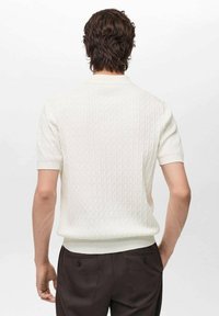 Short-sleeve knitted polo shirt in white, featuring a textured pattern and ribbed cuffs and hem. Back view shows a slim fit design.