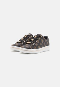 Schwarze Sneaker mit einer strukturierten Oberfläche, die ein goldfarbenes Logomuster, schwarze Schnürsenkel und eine weiße Gummisohle mit goldenen Akzenten aufweisen.