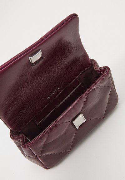 Burgundy leather handbag with quilted pattern, silver hardware, and a magnetic closure. Interior features card slots and logo detail.