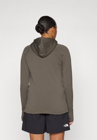 Donkergroene hoodie met een slim fit ontwerp, lange mouwen en een capuchon, gecombineerd met zwarte korte broek met een klein logo op de zoom.
