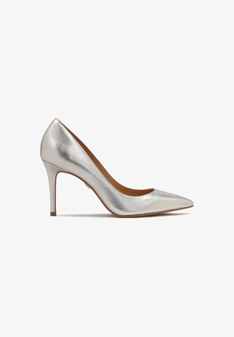Escarpin à talon haut en métal argenté à bout pointu avec un talon stiletto fin, présenté de profil sur fond blanc.