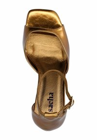 Bruine metalen open teen hoge hak schoen met een vlechtontwerp en enkelbandje. Het interieur heeft een gouden merk inlegzool.