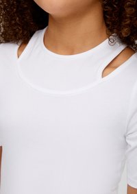 Weißes Kurzarmoberteil mit rundem Ausschnitt und Cut-Out-Details an den Schultern, aus einem weichen, dehnbaren Stoff gefertigt.