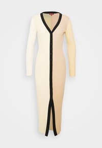 Robe longue en maille côtelée avec manches longues, boutonnage sur le devant, col en V bordé de noir, et bicolore crème et beige répartie verticalement.