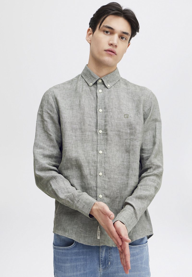 Camicia grigia a maniche lunghe con bottoni, realizzata in tessuto leggero, con colletto, bottoni frontali e un piccolo logo sul petto.