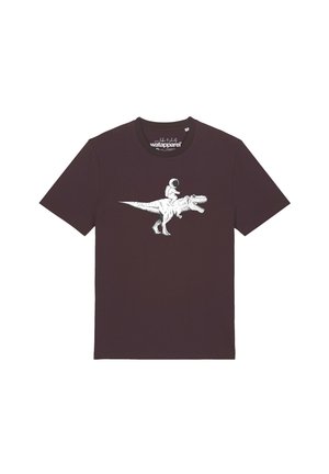 Donkerbruine T-shirt met witte grafische afbeelding van een astronaut die op een brullende Tyrannosaurus rex dinosaurus rijdt, in het midden van de borst.