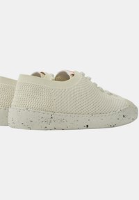 Helle beigen Sneakers mit einem Obermaterial aus Mesh, gesprenkelt grauer Gummisohle und minimalistischem Schnürdesign. Verfügt über eine bequeme, atmungsaktive Textur.