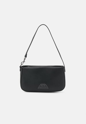 Bolso de hombro de cuero sintético negro con textura suave, forma trapezoidal, correa ajustable y logo en relieve en el frente.