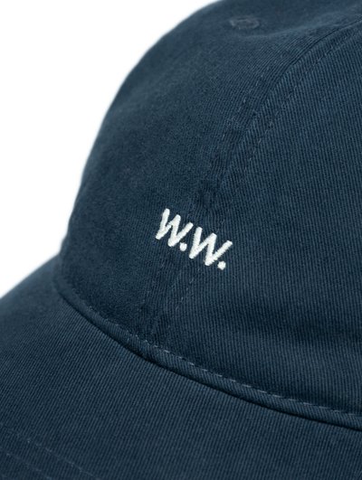 Căciulă de baseball albastră închisă, fabricată din țesătură de bumbac twill, cu litere albe brodate "W.W." pe față. Design structurat cu accente cusute.