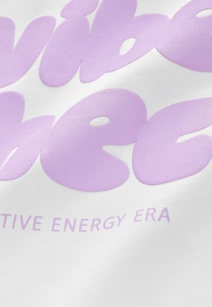 Biały materiał z dużym, miękkim, fioletowym napisem „vibe” oraz „creative energy era” w zaokrąglonej, zabawnej czcionce.