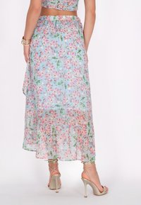 Bloemen maxi-rok in lichtblauw, gemaakt van doorzichtig materiaal met roze en groene bloemenpatronen, voorzien van een gerimpelde zoom en een zijsplit.